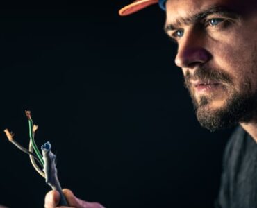 male-electrician-works-switchboard-with-electrical-connecting-cable (2) (1)